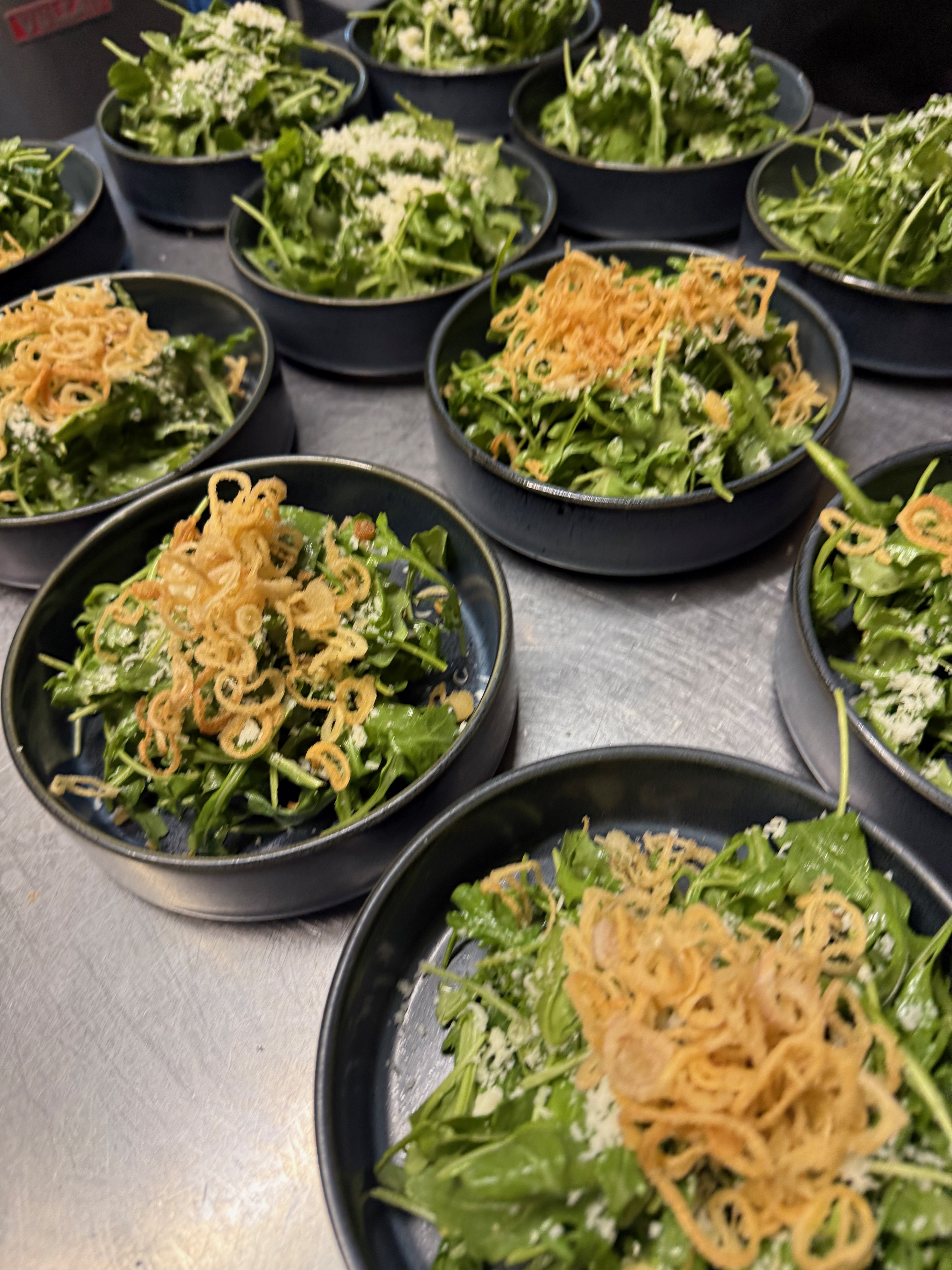 Arugula salads plated and ready for service