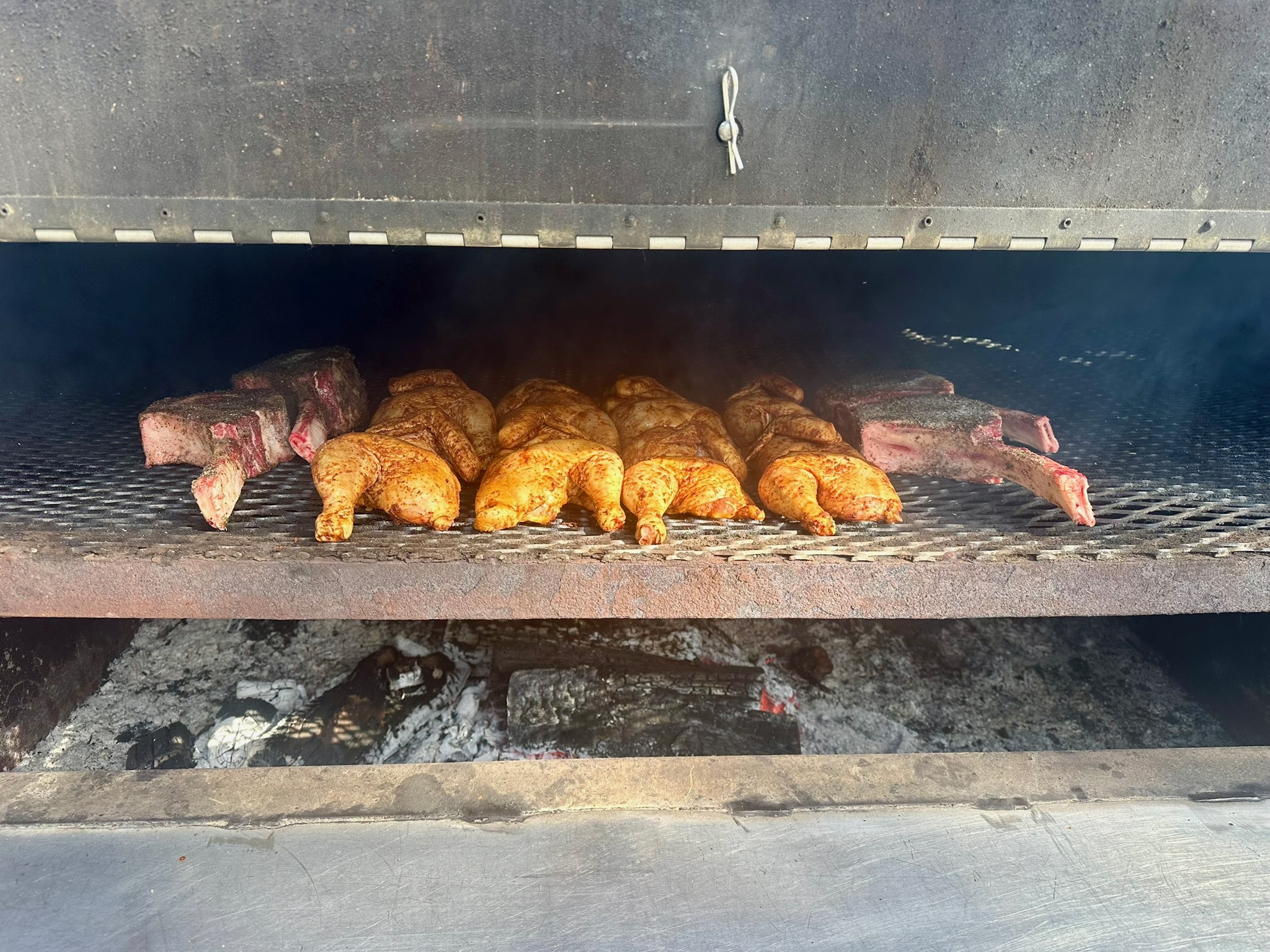 Smoker loaded with ribs and chicken